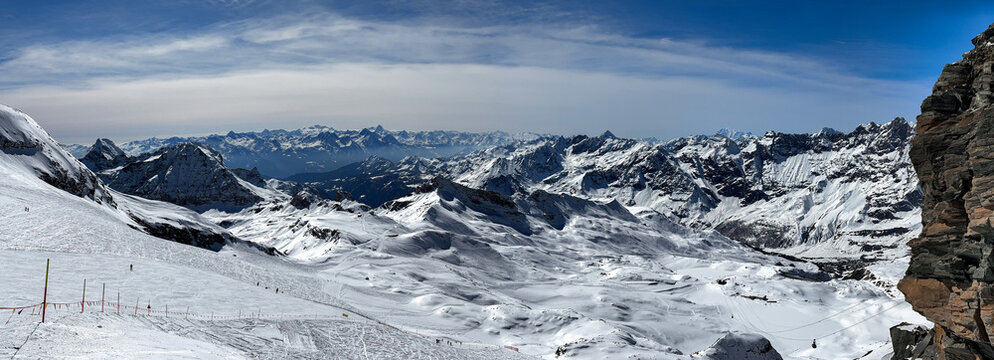 Wide panoramic view of the snowy Swiss Alps with dramatic mountain ridges, soft winter light, and untouched snowfields. High-resolution landscape capturing alpine beauty in winter. - Powered by Adobe