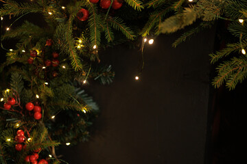 Festive Christmas Garland with Lights and Red Berries on Dark Background