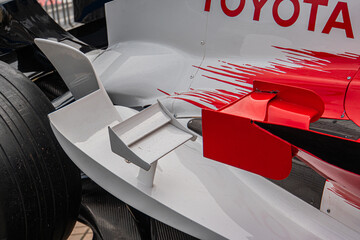 Obraz premium Close-up of a white and red Formula 1 Toyota TF-108 car, showcasing sleek aerodynamic design, natural lighting, outdoor setting pit lane or garage, no other object - Kyiv, Ukraine 10-10-2024