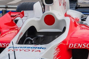 Obraz premium Toyota TF-108 Formula 1 car, white with red and black detailing, side profile view, sponsor logos, slick tires, rear wing, aerodynamic design, steering wheel, contro - Kyiv, Ukraine 10-10-2024