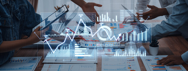 Business professionals engage in discussion while analyzing data trends through digital graphs in a modern office. Collaborative efforts drive strategy and performance improvements. Scalp