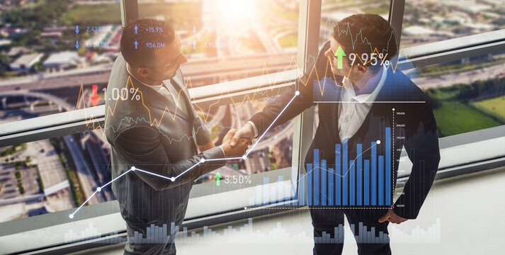 Two business professionals shake hands in a modern office, with financial graphs overlaying the city view, symbolizing growth and successful partnerships. Scalp - Powered by Adobe