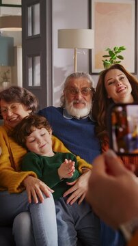 Unknown person taking pictures of big family on mobile phone