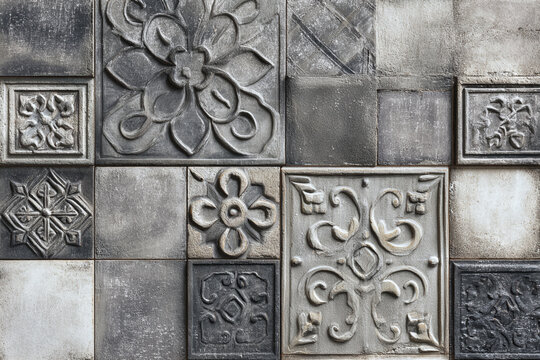 intricately carved stone tiles featuring floral and geometric patterns with a weathered aged appearance