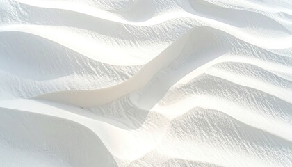Textured waves of pristine white sand dunes bathed in sunlight