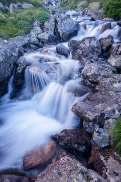 View of cascading water flows dynamically over rugged, moss-covered rocks, creating a serene scene in Rackova dolina valley, Pribylina, Zilina Region, Slovakia.