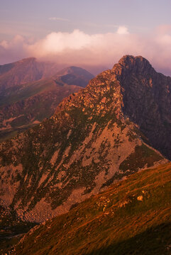 View of rugged mountain terrain under a soft, pastel sky, where peaks rise majestically, showcasing nature's grandeur and the allure of exploration, Jamnik, Zilina Region, Slovakia.