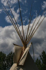 Top of Indigenous tipi against blue sky and clouds in western Canada. © Hans