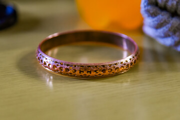 Bracelet made of copper alloy metal, with decorative perforations in the form of small hearts.