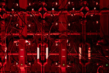 Large structured wall of electronic hardware containing rows of vertical components, extensive wiring paths, and illuminated sections, forming a detailed equipment array