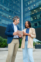 Diverse business colleagues discussing work using a tablet