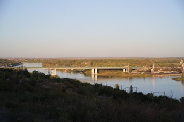 View of Aksai bridge. A natural landscape with trees and a river.
