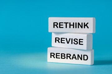 Rethink Revise Rebrand. White blocks with slogan Rethink Revise Rebrand.Conceptual words. Beautiful blue background. Business and Rethink Revise Rebrand concept. Copy space