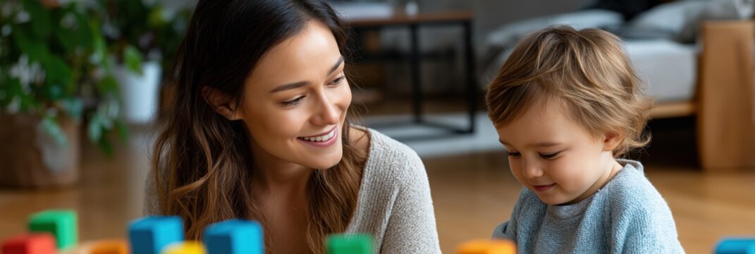 Caucasian female adult and child engaging in indoor play with colorful blocks