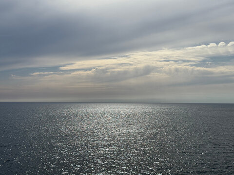 Glittering ocean and cloudy sky.
