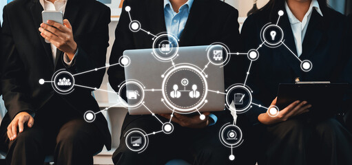 A professional business meeting showcases individuals engaging with technology in a collaborative environment, emphasizing the importance of connectivity and teamwork. Amity