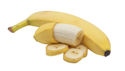 A whole ripe yellow banana and several slices of the same banana are arranged on a white surface, studio shot