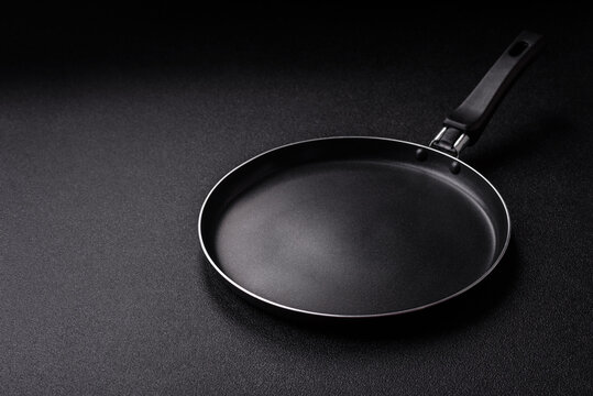 An empty black metal frying pan, kitchen utensils for cooking. An empty frying pan