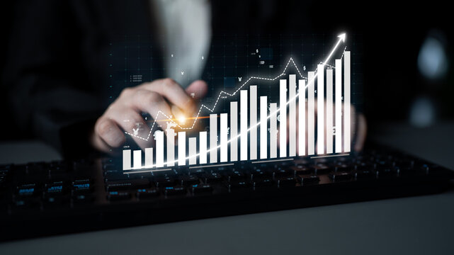 A businessman engages with a digital financial growth graph displayed over a keyboard, representing the importance of data in modern business decision-making. Impute