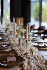 Elegant table setting for a cozy gathering filled with candles and fresh flowers
