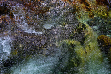 Top view of the rough mountain stream. Clean transparent water flows over the stones.