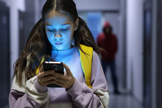 Child in danger. Girl using phone while man stalking her indoors, selective focus