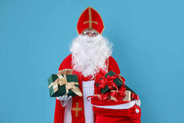 Saint Nicholas with sack full of gifts on blue background