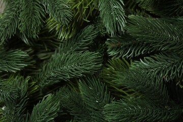 Branches of artificial Christmas tree as background, top view