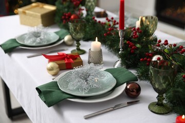 Festive table setting with Christmas decor and burning candles indoors, closeup