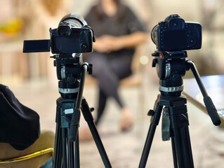 Cameras on tripods set up for a video interview in a studio setting