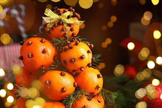 Christmas tree made of tangerines with cloves. Bokeh lights