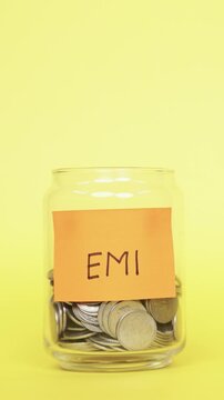 Vertical Video of Saving money for EMI. Putting Indian Rupee coins in Glass Jar