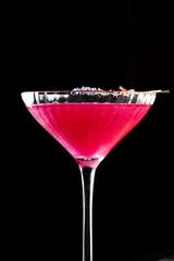 Close-up of a Cosmopolitan cocktail focusing on the middle of the glass, highlighting the vibrant red liquid and smooth texture.