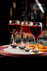 Four different drinks are arranged on a plate, offering a colorful and organized tasting experience.