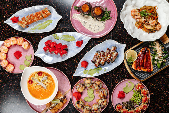 A variety of sushi sets displayed together in one image, showcasing assorted rolls, nigiri, and garnishes in a colorful and appetizing arrangement. - Powered by Adobe