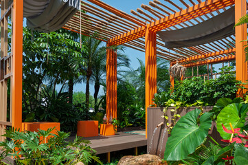 Contemporary pergola in a landscaped garden surrounded by dense foliage and water streams. Useful for design firms, real estate branding and outdoor renovation guides.