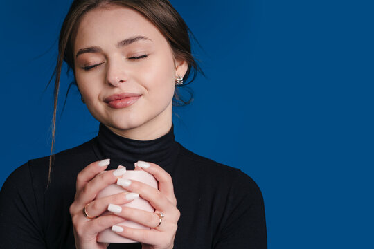 Young lady peacefully drinking coffee in cozy studio setting