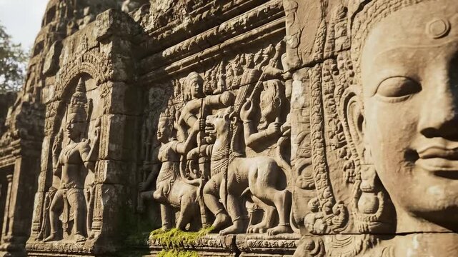 Ancient stone carving detail of buddha face and bas relief wall illuminated by warm sunlight in angkor wat temple complex