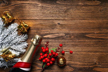 Rustic Christmas and New Year celebration background with a bottle of champagne, frosted pine...