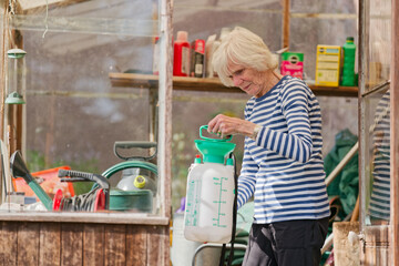 Senior elderly person active lifestyle in garden greenhouse