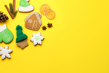 Tasty gingerbread cookies, spices and Christmas decor on yellow background, flat lay. Space for text