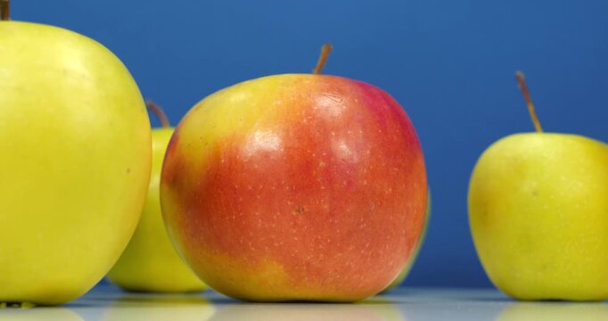Fresh apples rotates on blue backdrop