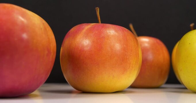 Red apples rotates on black backdrop, close-up shot studio video