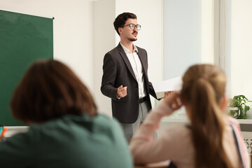Teacher explaining information to children during lesson in classroom
