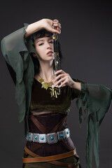 Forest elf warrior with short black hair, flowing fabric blouse and leather dagger belt.