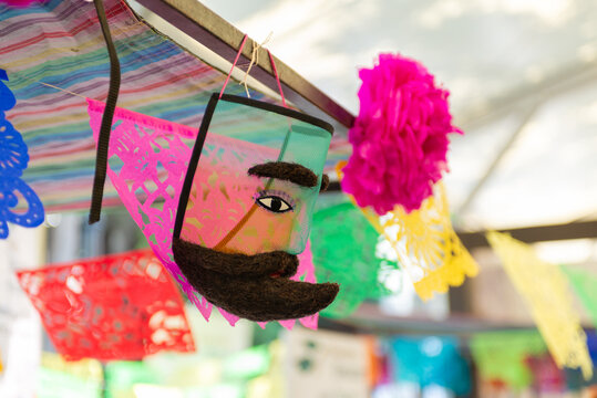 A brightly colored traditional chinelo mask hanging as a decoration.
