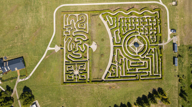 Aerial view of the intricate maze, a puzzle etched in green, contrasting with the surrounding golden fields, a testament to human design, El Hoyo, Chubut Province, Argentina.