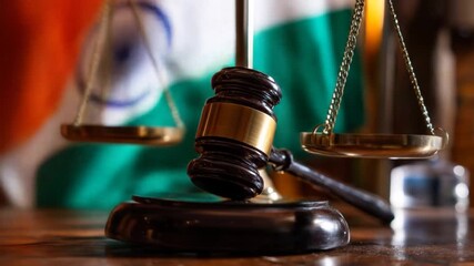 Wooden gavel beside balanced scales with blurred flag background