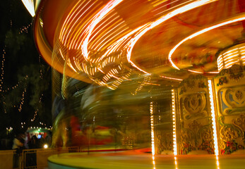 Carousel lights creating swirling patterns of illumination at night.