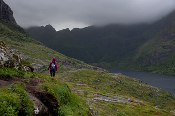 Hikers trekking in a nature trail. Lofoten Islands, A village Norway